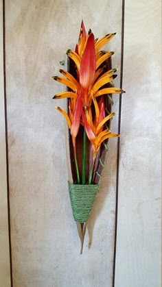 an arrangement of flowers is hanging on the wall