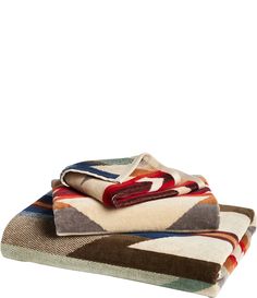 three towels stacked on top of each other in different colors and patterns, with one folded