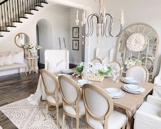 the dining room table is set with white chairs