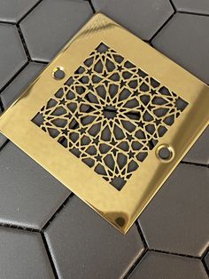 a square metal floor grate with an intricate design on it