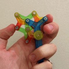 a hand holding a small plastic toy in it's palm