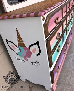 an old dresser has been painted with unicorn's face and pink stripes on it