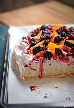 there is a cake with fruit on it sitting on a tray and ready to be eaten