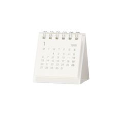 a white desk calendar sitting on top of a table