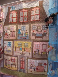 a child's room with a large quilt on the wall and stuffed animals hanging from it