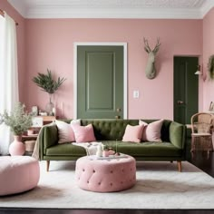 a living room with pink walls and green furniture