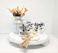 a white table topped with vases filled with flowers next to jars and other items