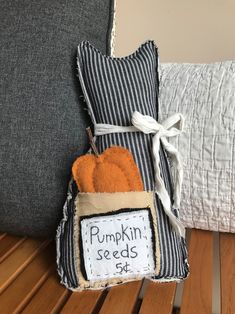 a pumpkin seed bag sitting on top of a wooden table next to a pillow with the word pumpkin seeds written on it