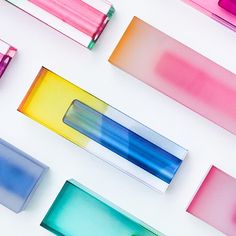 several different colored tubes are arranged on a white surface, including one blue and one pink