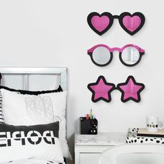 a bedroom decorated in pink and black with heart shaped glasses