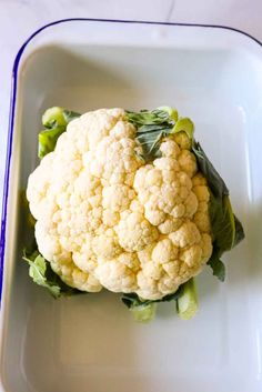 cauliflower on a white plate with green leaves