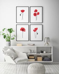 three red poppies are hanging on the wall above a white chair and ottoman in this modern living room