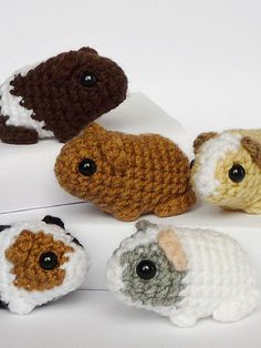 small crocheted animals sitting next to each other on top of a white surface