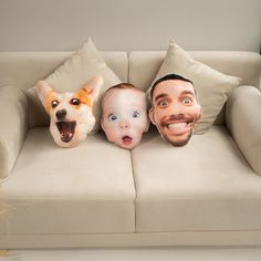 three pillows with the faces of two men and a dog on them are sitting on a couch