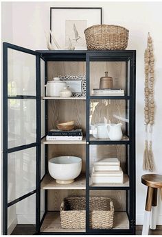 an open bookcase filled with books and bowls