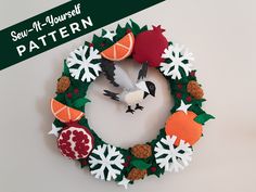 a wreath made out of felt with an orange and white bird sitting on top of it