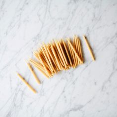 several sticks of pasta on a white marble surface