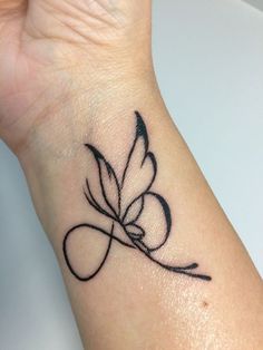 a black ink tattoo on the wrist of a woman's hand with a butterfly