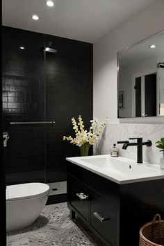 a black and white bathroom with flowers in the sink