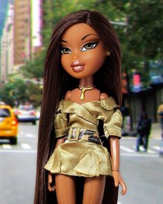 a close up of a doll with long hair on a city street near a taxi