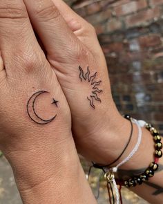 two people with matching tattoos on their hands, one has a sun and the other has a moon