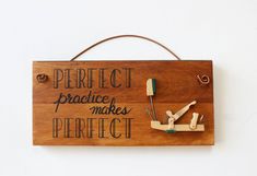 a wooden sign that says perfect practice makes perfect with scissors and pegs attached to it