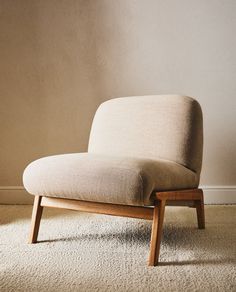 a chair sitting on top of a carpet covered floor next to a wall with a wooden frame