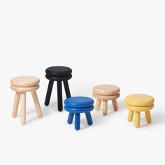 four stools in various colors and sizes on a white background, one is black, the other is yellow