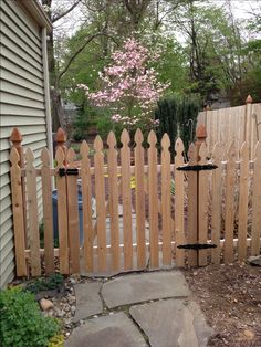 a wooden fence in front of a house with a bird feeder on it's side