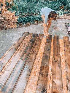 a woman is working on some wood planks