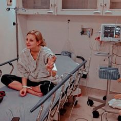 a woman sitting on top of a hospital bed