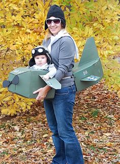 a woman holding a baby in a plane costume