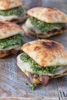 several sandwiches with meat and pesto on them