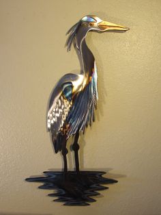 a metal bird is standing on top of water