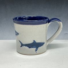 a blue and white mug with a shark design on it