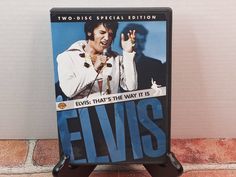 the elvis dvd is on display in front of a brick wall