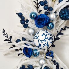 blue and white ornaments are on display against a white background with black leaves, branches, and flowers