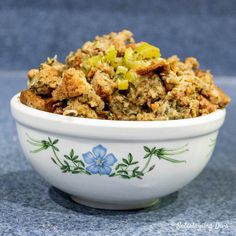 a white bowl filled with food sitting on top of a blue tablecloth covered floor