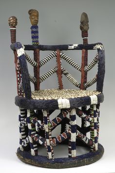 a chair made out of sticks and rope with two heads on top of the back