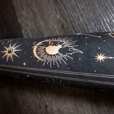 a tie with an image of the sun and moon on it is laying on a wooden surface