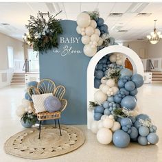 a baby in heaven balloon arch with blue and white balloons