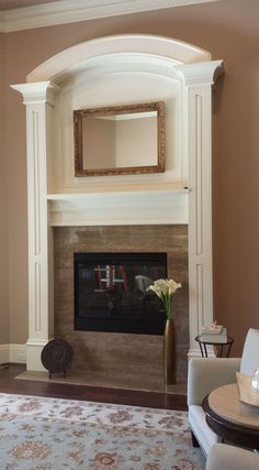 a living room filled with furniture and a fire place under a mirror on the wall