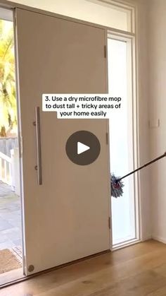 a woman is using a mop to clean the front door