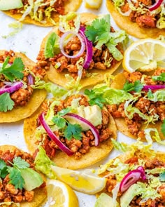 several tacos with meat, lettuce and red onions on them are arranged on a sheet of paper