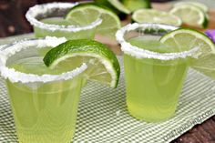 three glasses filled with limeade on top of a table