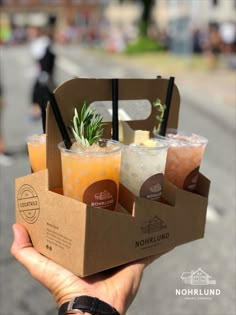 a person holding up a box with drinks in it