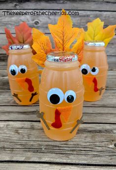 three plastic cups with fake leaves in the shape of turkeys and faces on them