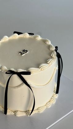 a white cake with black ribbon on top