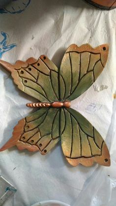 a green and brown butterfly sitting on top of a table