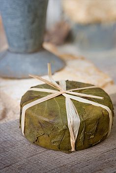 a wrapped present sitting on top of a wooden table next to a potted plant